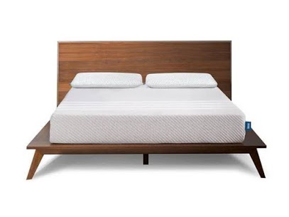 A wooden bed with a mattress and two pillows on it